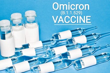 COVID-19 VACCINE for new strain omicron. Ampoules and vials on light blue background with text...