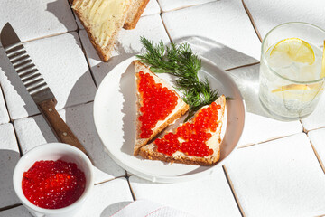 Sandwiches with red caviar on a white plate