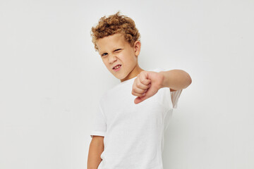 Photo of young boy in a white t-shirt posing fun isolated background