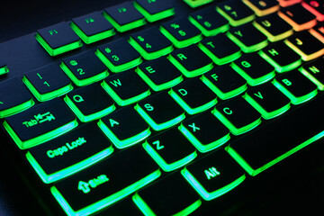 RGB gaming keyboard. Bright colorful keyboard, soft focus. Keyboard with RGB light, blurred background. Close-up.