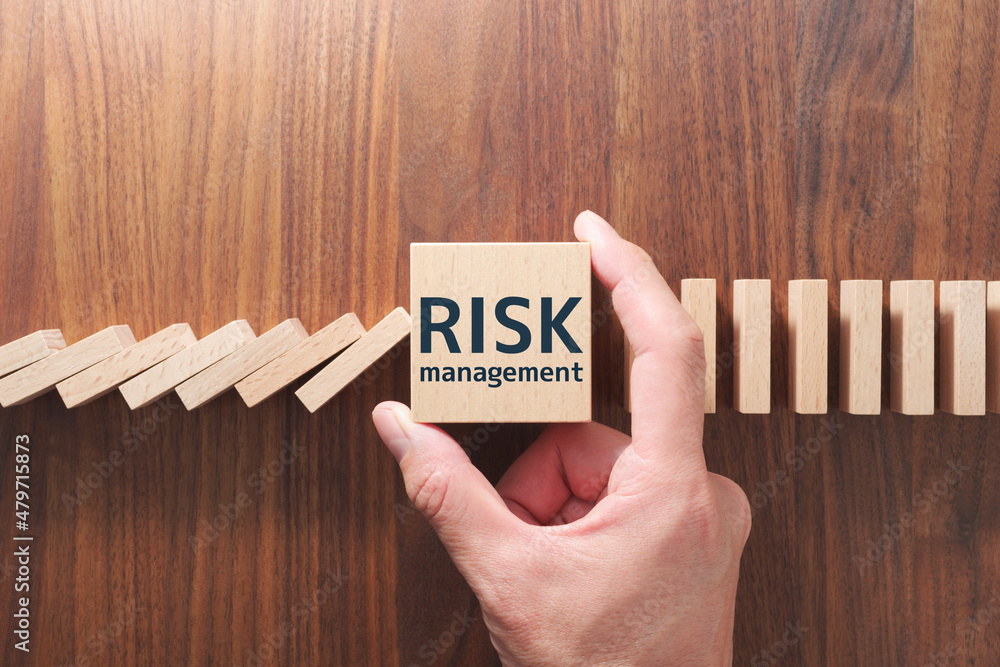 Poster concept image of stopping domino effect. risk management. putting wood cube and stopping domino.