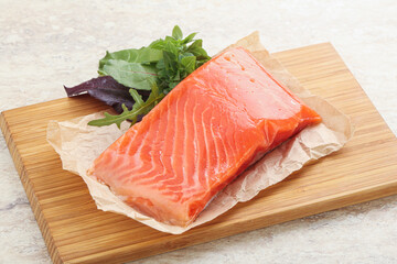Raw salmon fillet over board