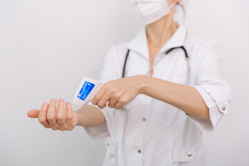 Temperature measurement gun in doctor hands. Close-up shot of doctor wearing protective surgical mask ready to use infrared isometric thermometer gun to check body temperature for virus symptoms.