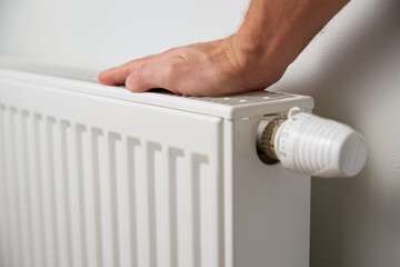 Hand adjusting temperature on heating radiator thermostat, Turning heat radiator knob to control heat in home