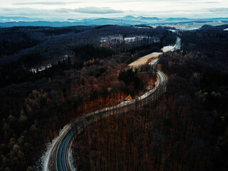 Winding road through forest, landscape with curvy highway among countryside, aerial view
