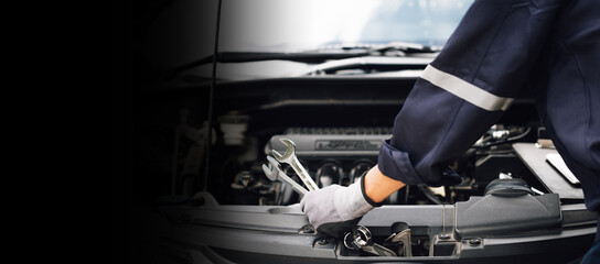 Hand of car mechanic with wrench. Auto repair garage. mechanic works on the engine of the car in...