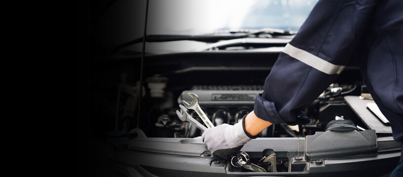 Hand of car mechanic with wrench. Auto repair garage. mechanic works on the engine of the car in the garage. Repair service. Concept of car inspection service and car repair service.