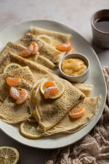piles de crêpes fait maison avec crème lemon curd au citron et clémentines et tasses de thé