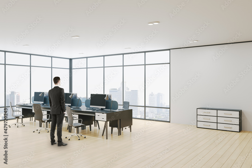 Wall mural businessman standing in modern concrete coworking office room interior with panoramic window wooden 