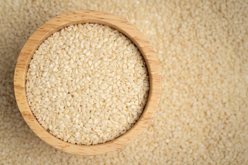 Close-up of Organic White Sesame seeds on the self background. Top view.