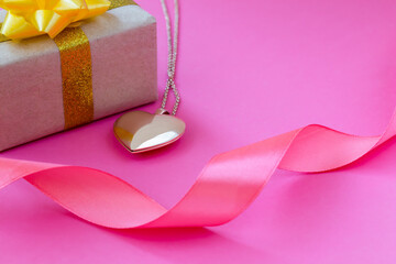 Gift, heart, ribbon on a pink background
