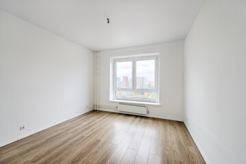 Empty room after repairs in an apartment building. Fresh renovated room with wooden floor