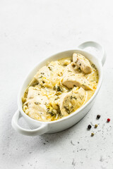 Creamy lemon pepper chicken fillet creamy sauce in ceramic dish. Space for text.
