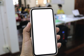 Mockup woman hand holding the smart phone with blank white screen infront of other people. Business and technology concept