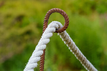 Selective focus on rope fence barrier with green background.