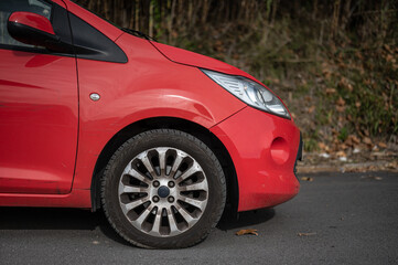Small red city utility car, side detail wheel