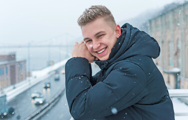 Smiling young handsome student, blonde guy, lifestyle of teen life. Portrait at winter