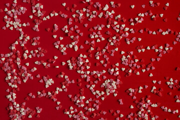 Sugar hearts on red paper. Beautiful festive background about love. Romantic valentines day card. Top view, flat lay