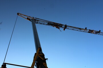 evocative image of the silhouette of a crane on a construction site at dusk 