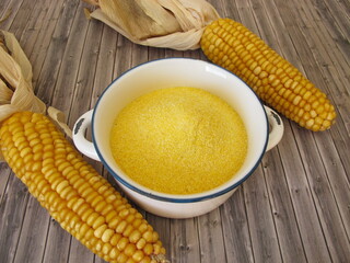 Corn semolina in a pot and maize ears