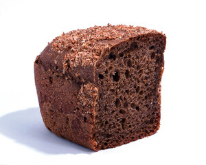 Half a loaf of rye bread close-up on a white background. A textured piece of dark bread with a sprinkle of bran. Healthy proper nutrition