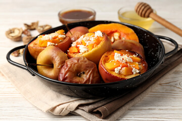 Concept of tasty food with baked apples on white wooden table
