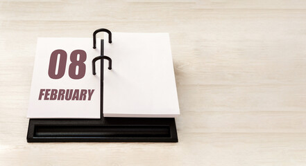 february 8. 8th day of month, calendar date.  Stand for desktop calendar on beige wooden background. Concept of day of year, time planner, winter month