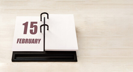 february 15. 15th day of month, calendar date.  Stand for desktop calendar on beige wooden background. Concept of day of year, time planner, winter month