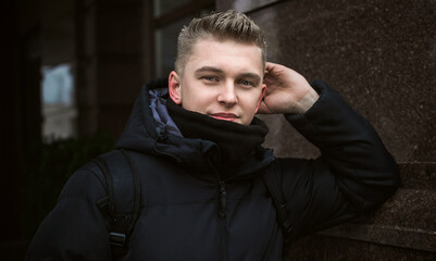 Obraz premium Portrait of young blonde guy Nordic appearance, lifestyle of young people. Handsome guy close up, winter day thinking about something