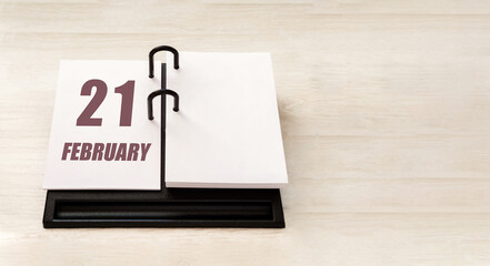 february 21. 21th day of month, calendar date.  Stand for desktop calendar on beige wooden background. Concept of day of year, time planner, winter month