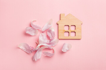 Wooden symbol of the house and pink flowers, sweet dream home concept