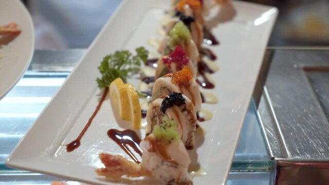 Beautifully presented sushi maki roll colorfully topped with masago and roe, HD