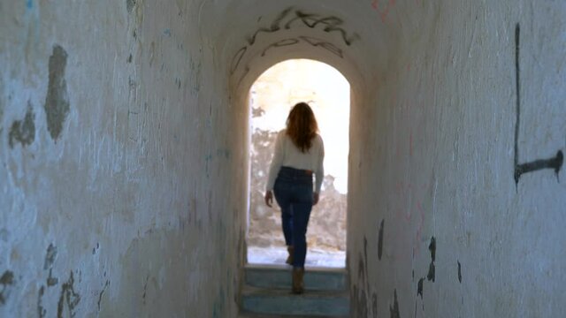 Girl Walks In A White Tunnel And Goes To The Exit From The Door Going Out Of Focus 