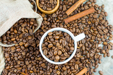 top view, close-up of coffee beans in a cup, bowl, bag. cinnamon sticks, anise stars. original composition.