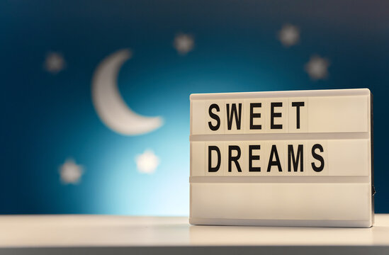 Sleeping And Bedtime Concept - Close Up Of Customizable Light Box With Sweet Dreams Words Over Moon And Night Stars On Blue Background