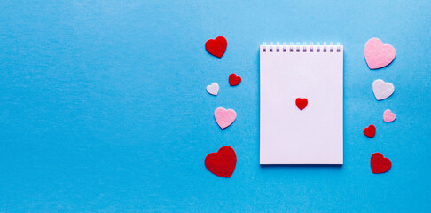 Valentine's day composition with notebook list and hearts on blue background. Wedding, birthday, woman's and mother day concept. Flat lay, top view, copy space, place for text, empty, mock up, banner