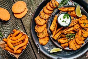 Set of homemade baked sweet potato fries with lime and herbs. banner, menu, recipe place for text,...