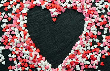 Multicolored candy hearts on a black background in the shape of a heart. Concept Valentine's Day. - 479732215