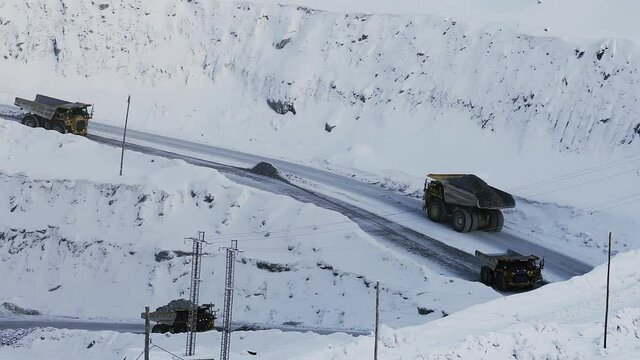 Industrial view of opencast mining quarry with lots of machinery at work. Extraction of gold, copper. Work of trucks in an open pit on gold mining