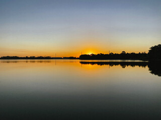 Sunrise reflection on the horizon over lake