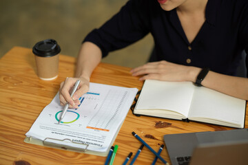 Fototapeta premium Accountant working and analysing a financial data graph report