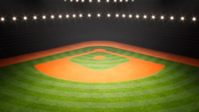 Empty baseball stadium during the night. Grass and orange dirt in the spotlight