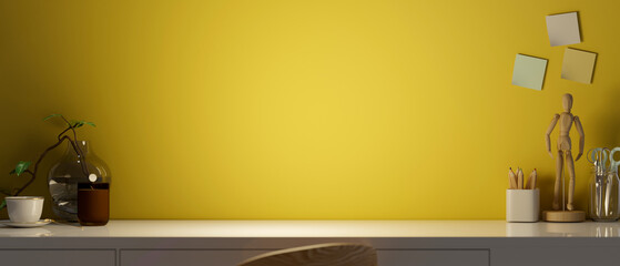 Creative workspace with stationery, decor and copy space over yellow background.