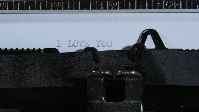 Typing the expression I love you with an old manual typewriter