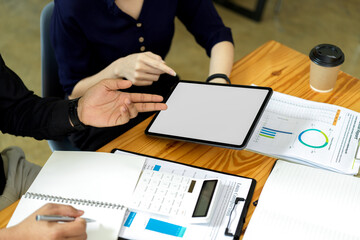 Workspace with financial report paperwork and businesspeople.