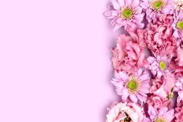 Frame made of eustoma and aster flower texture on a purple background. Greeting card concept for springtime holidays. Gentle floral composition.