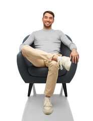 people and furniture concept - happy smiling man sitting in chair over white background
