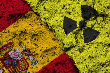 Concept of the Nuclear Energy Policy of Spain with a flag and a radiation hazard sign painted on a rough wall