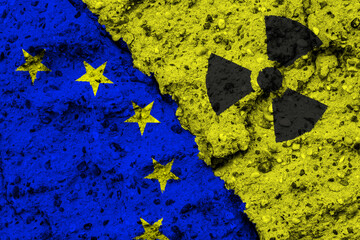 Concept of the Nuclear Energy Policy of the European Union with a flag and a radiation hazard sign painted on a rough wall