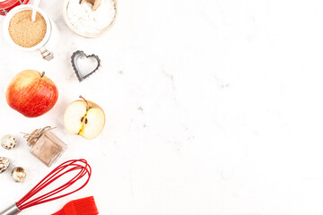 A frame with baking ingredients for Valentine's Day or Birthday, a culinary background with pastries - whisk for whipping, cookie molds, apples, sugar, flour. White background, top view